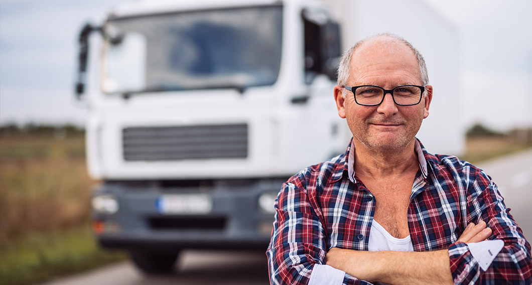 Older man standing in front of a truck